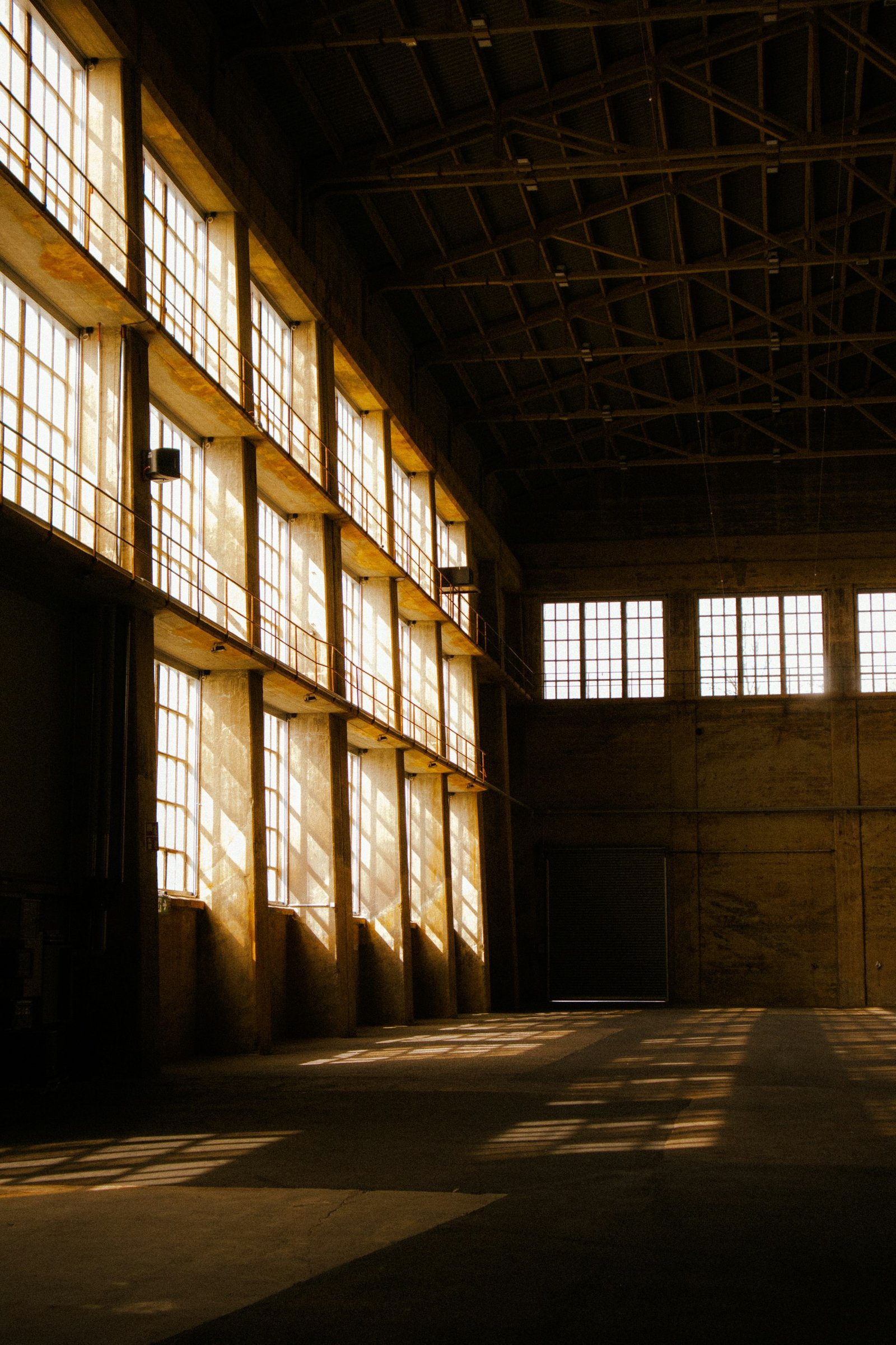 A large industrial building lit by warm golden light — solidity and structure.